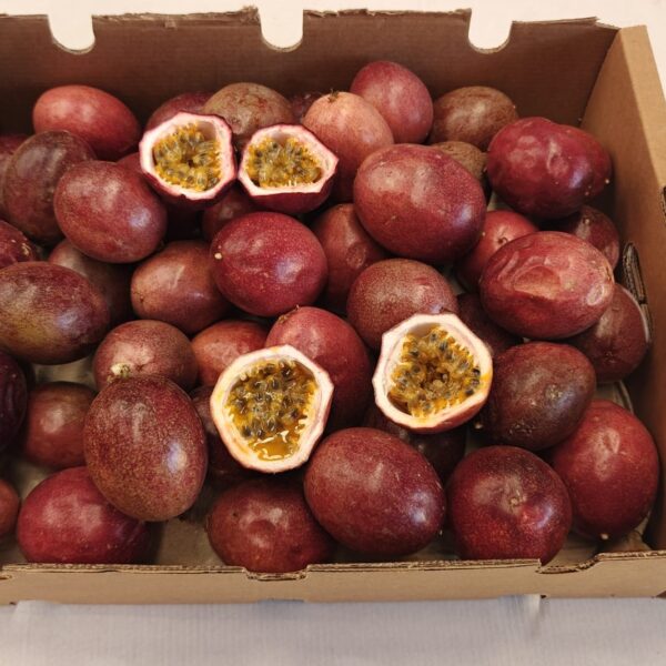 Caja de maracuyás ecológicas con una fruta abierta mostrando su pulpa anaranjada.