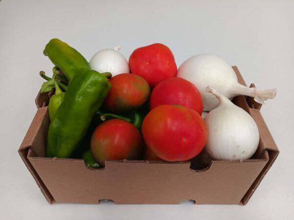 Caja ecológica con pimientos verdes, tomates y cebollas frescas, cultivadas sin pesticidas y directas de Antonio, un agricultor local.